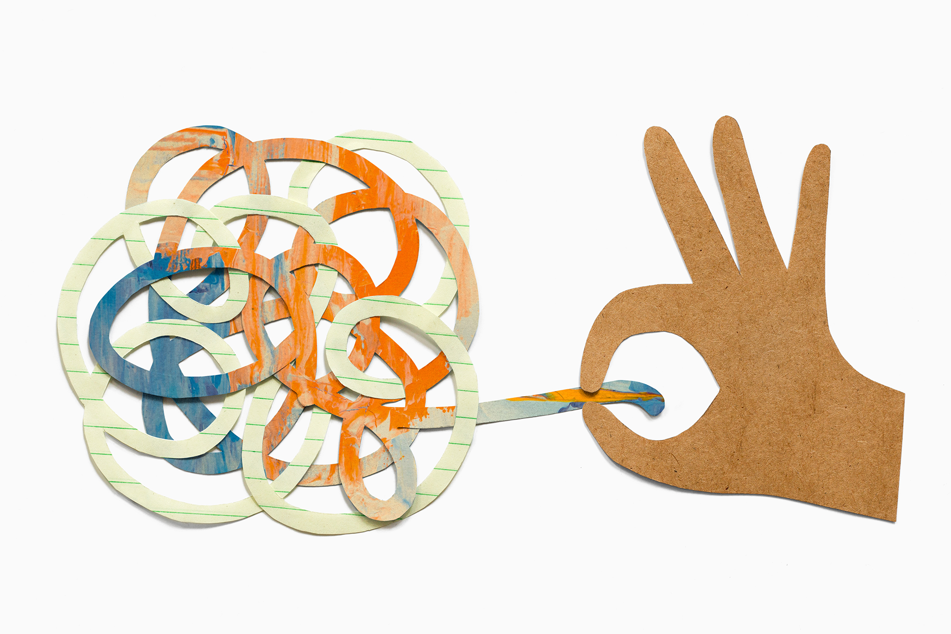 A photograph of paper cut into the shape of a hand pulling on a knotted bundle.