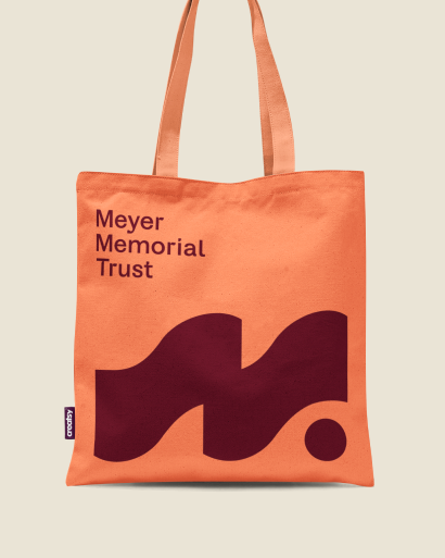 Orange and maroon Meyer Memorial Trust tote bag featuring the logo.