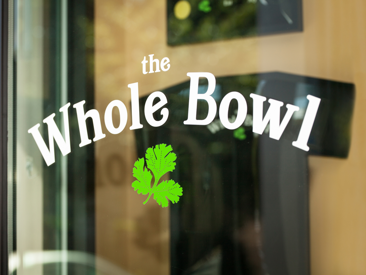 The Whole Bowl decal displayed on a glass door.
