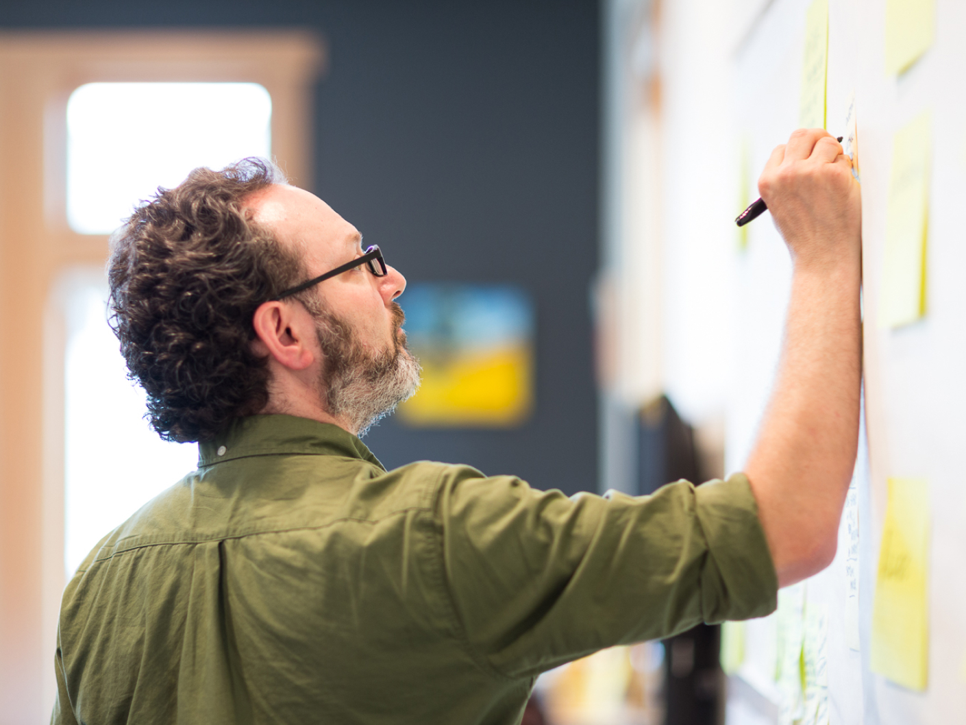 Scott writing on post it notes during a workshop.