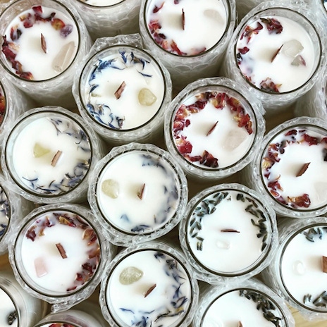 The tops of a group of candles in glass jars.