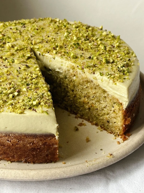 A slice missing from a pistachio cake