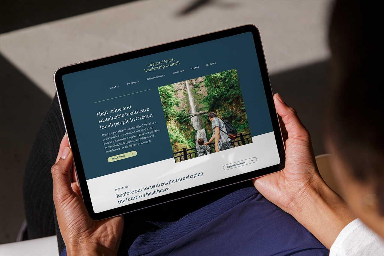 A closely cropped photograph of a tablet in a person's hands, with the OHLC website open in the browser.