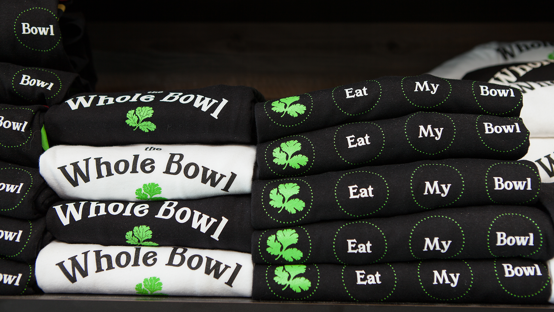 A stack of branded shirts being displayed in a restaurant.